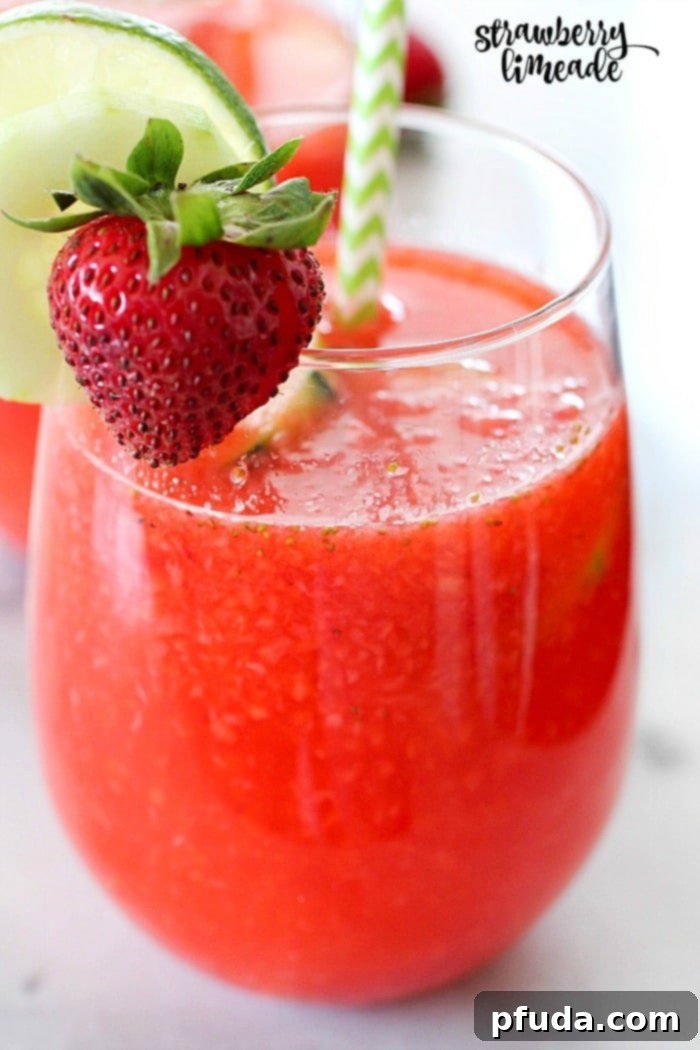 A vibrant glass of homemade strawberry limeade with fresh strawberries, lime slices, and cucumber garnish, perfect for a hot summer day. This lower-sugar copycat recipe from The Habit Burger Grill is made with Truvía® sweeteners.