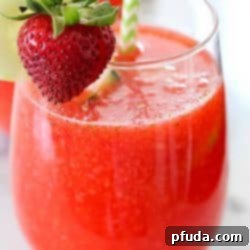 A tempting image of a glass of strawberry limeade, garnished beautifully, enticing viewers to try this easy and refreshing recipe at home.