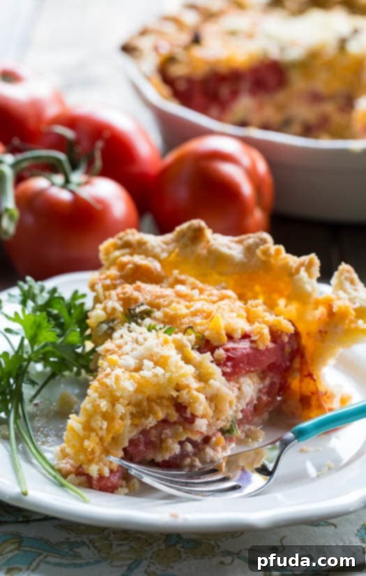 Hearty and savory Tomato Pie, layered with fresh summer tomatoes, cheese, and herbs in a flaky crust, ideal for gatherings or family dinner.