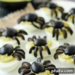 Celebrate Halloween with Spooky Spider Avocado Deviled Eggs! Your party guests will love these creepy crawly olive spiders on top of ghoulishly green avocado deviled eggs!