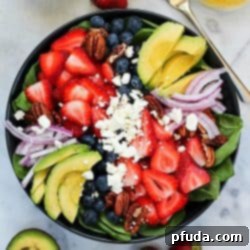 The ultimate spinach salad with avocado, berries, feta, and a homemade honey-garlic vinaigrette. So easy and flavorful!