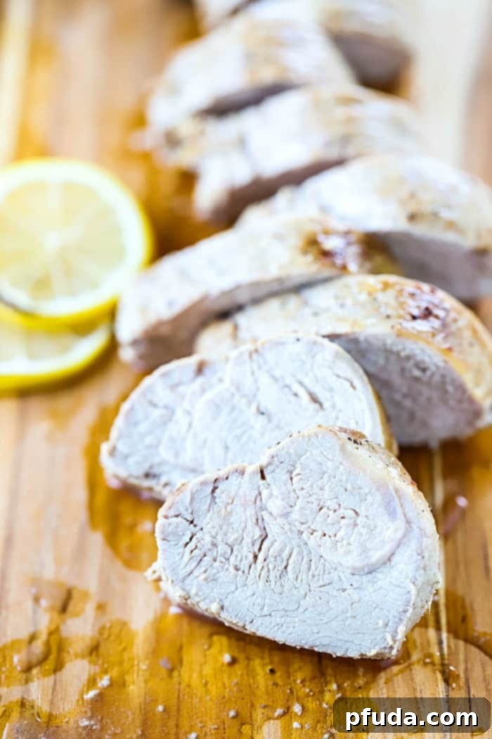 A beautifully plated baked pork tenderloin, garnished with fresh herbs and surrounded by ingredients for its savory marinade, highlighting its ease and deliciousness.