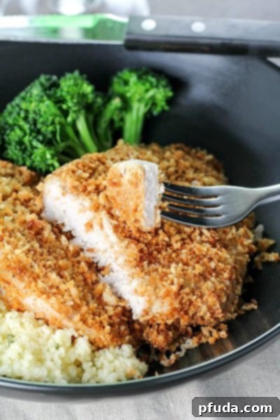 Tender, Flavorful Crispy Baked Breaded Pork Chops on a plate with a side dish.