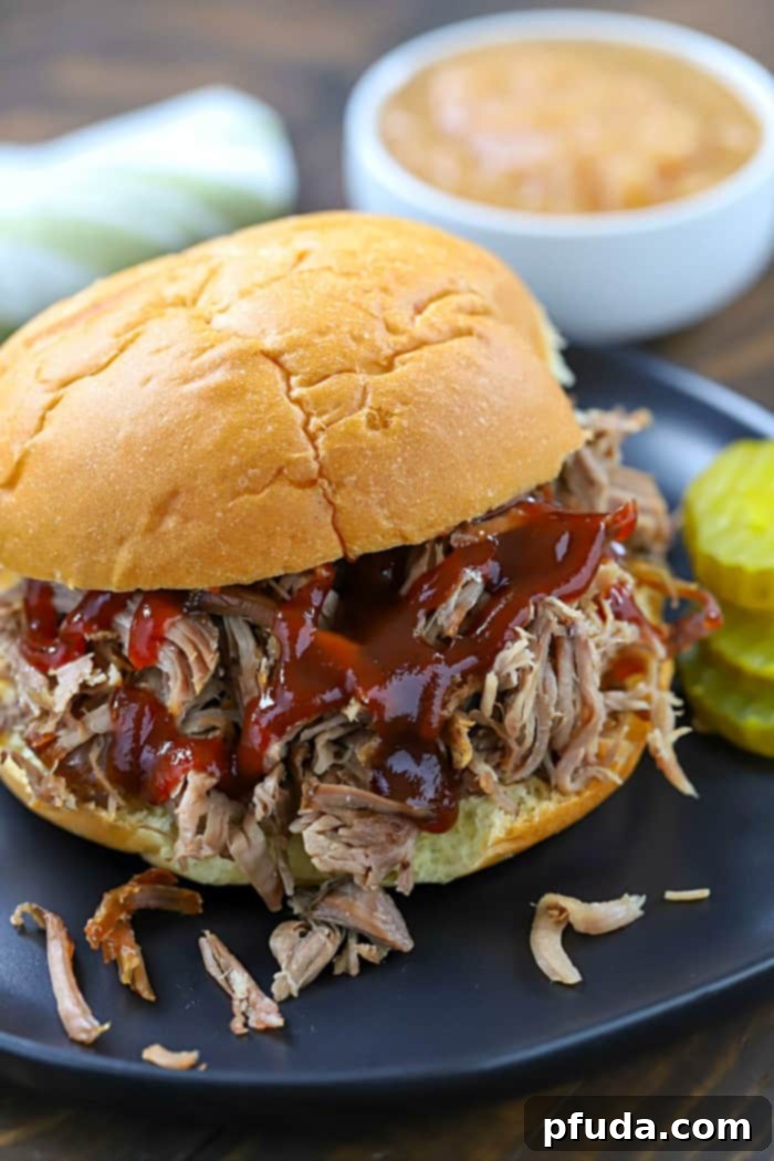 The Ultimate Pulled Pork Sandwich Recipe 3 Tender, shredded pulled pork on a bun with rich BBQ sauce, showcasing the simplicity of this incredible recipe.
