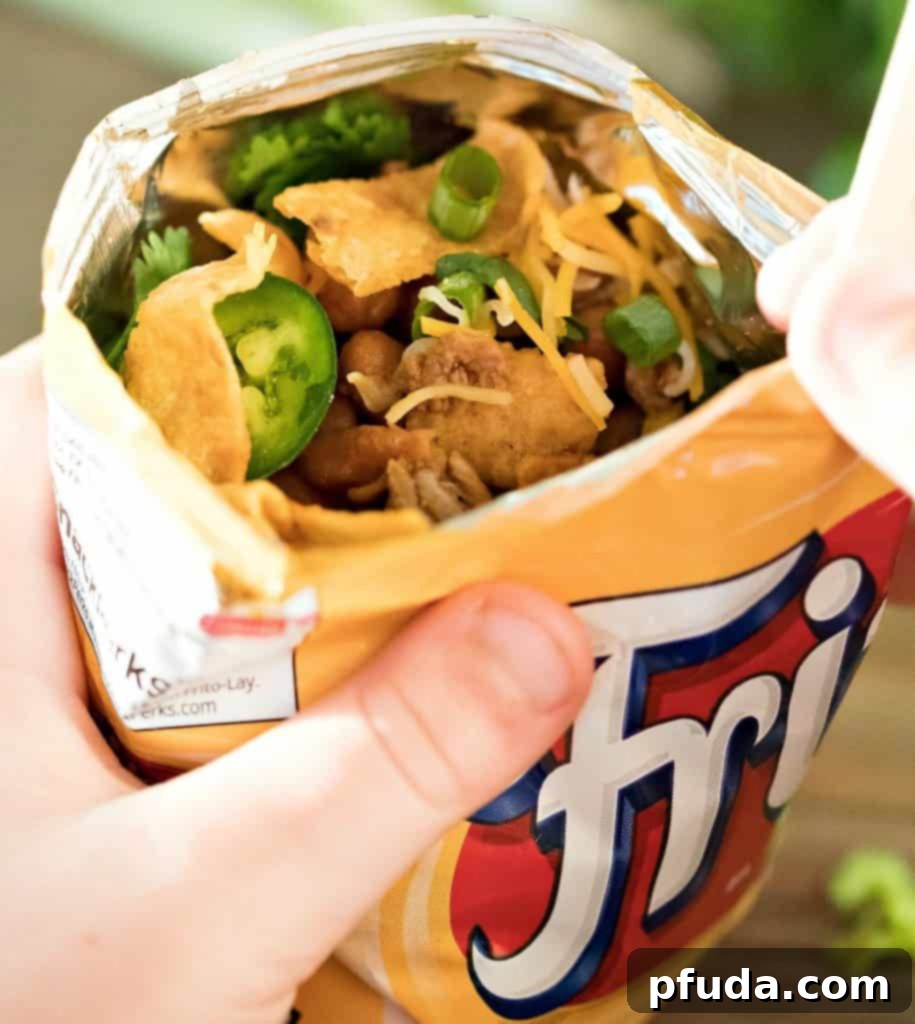 Stride and Savor Frito Pie 2 Frito bag filled with ground meat and beans with taco toppings and a fork.