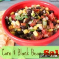 A beautifully presented bowl of Corn & Black Bean Salsa with a side of crispy tortilla chips.
