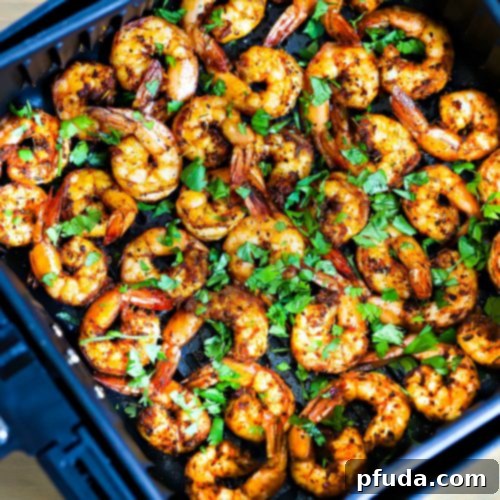 A pile of air fryer shrimp on a white plate.