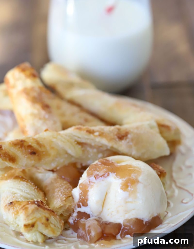 Cinnamon Apple Strudel Spirals 5 A plate full of strudel breadstick twists with a side of vanilla ice cream topped with apple pie filling.