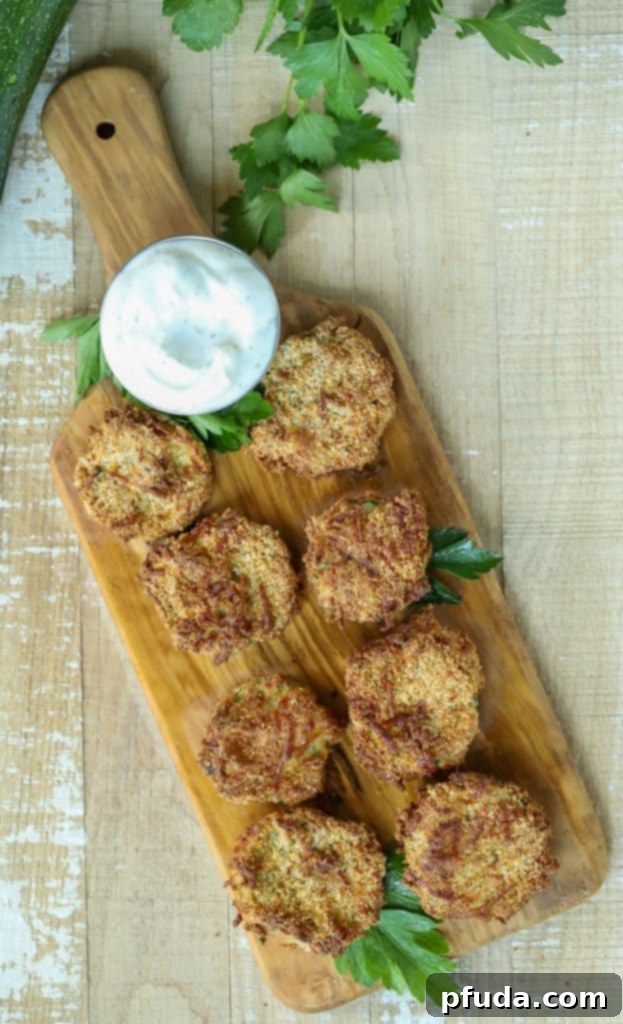 Overhead shot of Zucchini Chips with a dipping sauce on a cutting board.