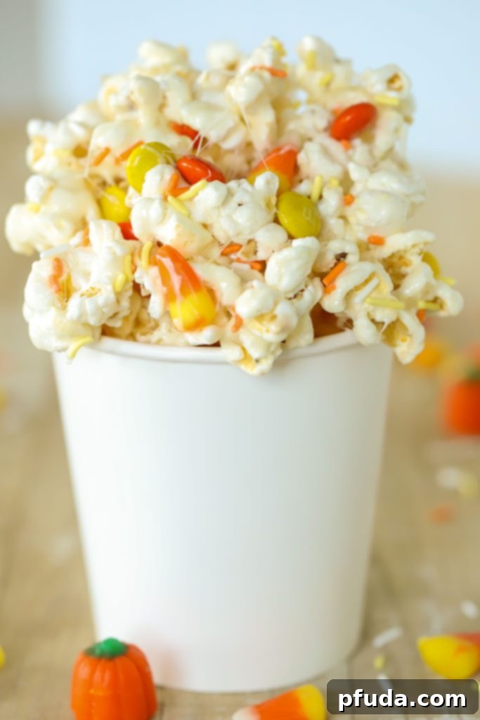 No Bake Candy Corn Popcorn Clusters 5 Container filled with Fall Candy Corn Popcorn, ready for a party