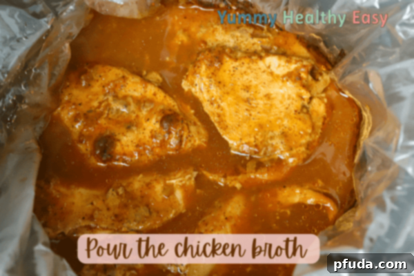 Easy Slow Cooker Low-Sodium Shredded Taco Chicken 6 Crock Pot filled with boneless skinless chicken breasts, topped with low sodium taco seasoning and broth.