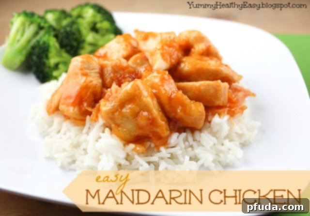 Crispy homemade Mandarin Chicken pieces coated in a glossy, orange sauce, served with rice