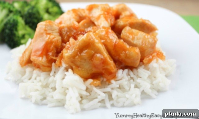 Close-up of golden-brown Mandarin Chicken pieces in a pan, coated in the sweet and sour sauce