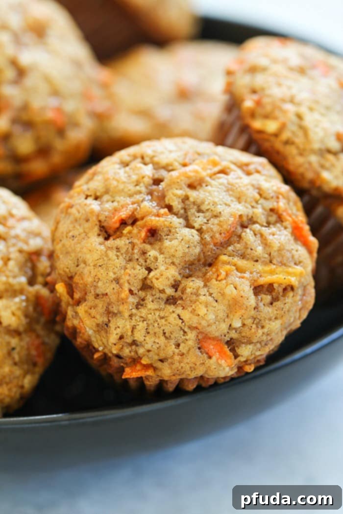 Moist and flavorful Apple Carrot Muffins, also known as Sunshine Muffins, featuring carrots, apples, coconut, cinnamon, and nutmeg. A delightful aroma fills the kitchen.
