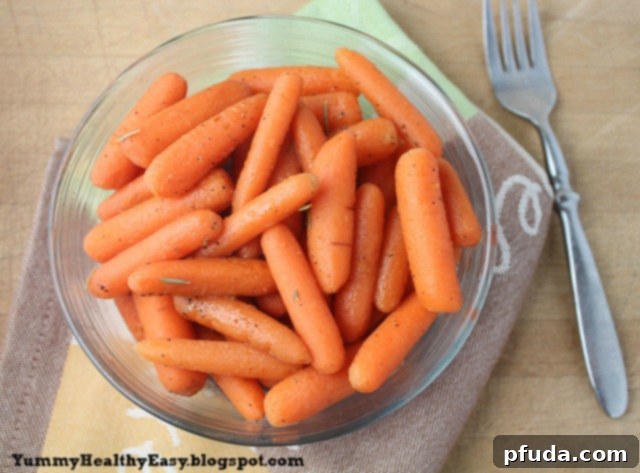 A large serving bowl filled with sweet and savory brown sugar glazed carrots, with a fork resting beside it.
