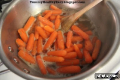 Step-by-step instruction: The brown sugar glazed carrots are simmering in the pan, with the liquid reducing to a rich glaze.