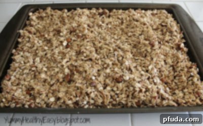 Granola mixture spread evenly on a cookie sheet