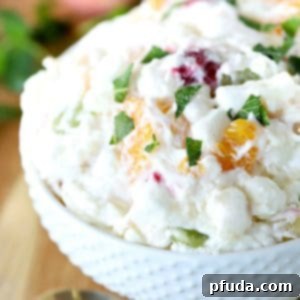 Square image - White bowl filled with fruit salad.