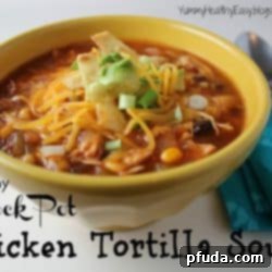 Healthy Crock Pot Chicken Tortilla Soup ready to serve, garnished with fresh cilantro and lime wedges.