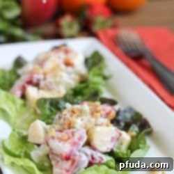 Lightened Waldorf Salad on lettuce leaves on a white plate.
