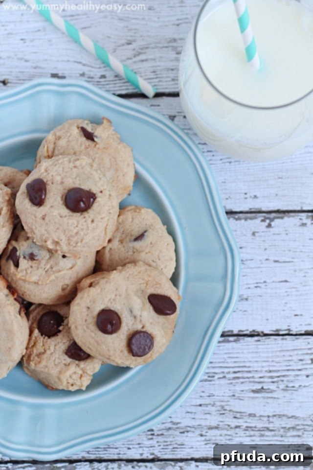 A plate of golden brown easy Bisquick Chocolate Chip Cookies with a glass of milk.