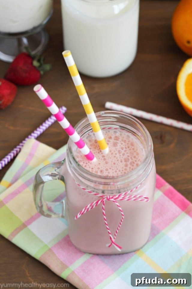 A vibrant Good Morning Smoothie, ready to be enjoyed, featuring pomegranate, strawberry, orange, and banana, crafted with Real California Milk and Yogurt.