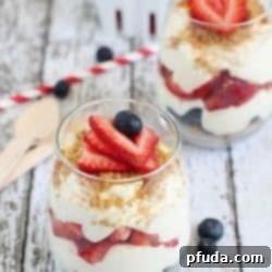 No-Bake Cheesecake Parfaits - layered with graham cracker crumbs, sliced strawberries, blueberries and easy no-bake cheesecake filling. Perfect for 4th of July!
