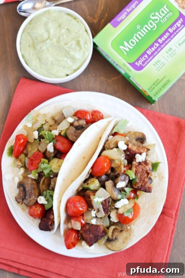 Two hands holding a Roasted Vegetable and Black Bean Taco, showcasing the vibrant ingredients.