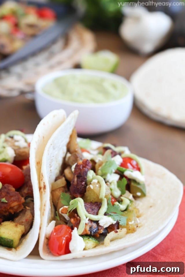 A spread of fresh vegetables for roasting, including zucchini, mushrooms, onions, and cherry tomatoes, ready for a healthy meal.
