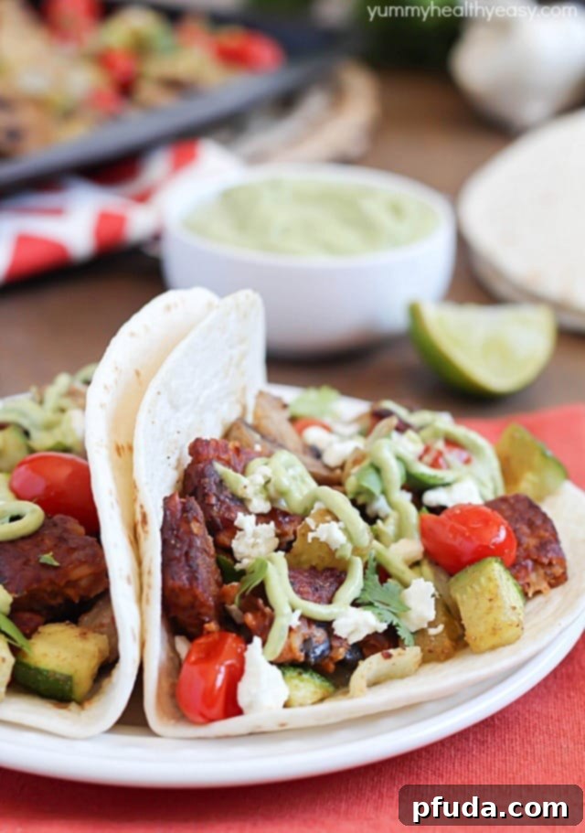 A vibrant close-up of a Roasted Vegetable and Black Bean Taco, ready to be eaten, highlighting the fresh toppings.