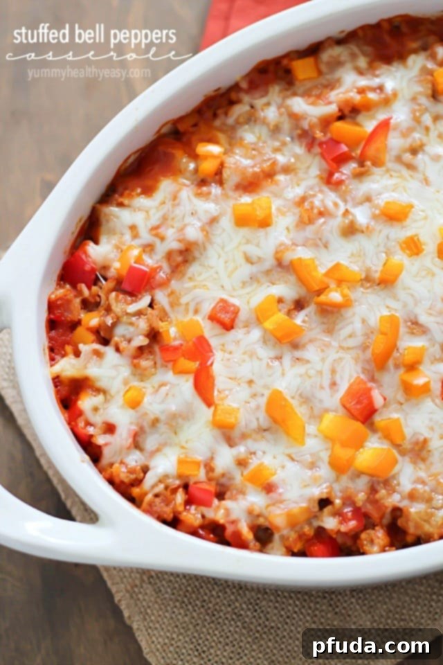 A vibrant casserole dish filled with baked stuffed bell pepper casserole, featuring ground turkey, rice, bell peppers, and melted cheese on top.
