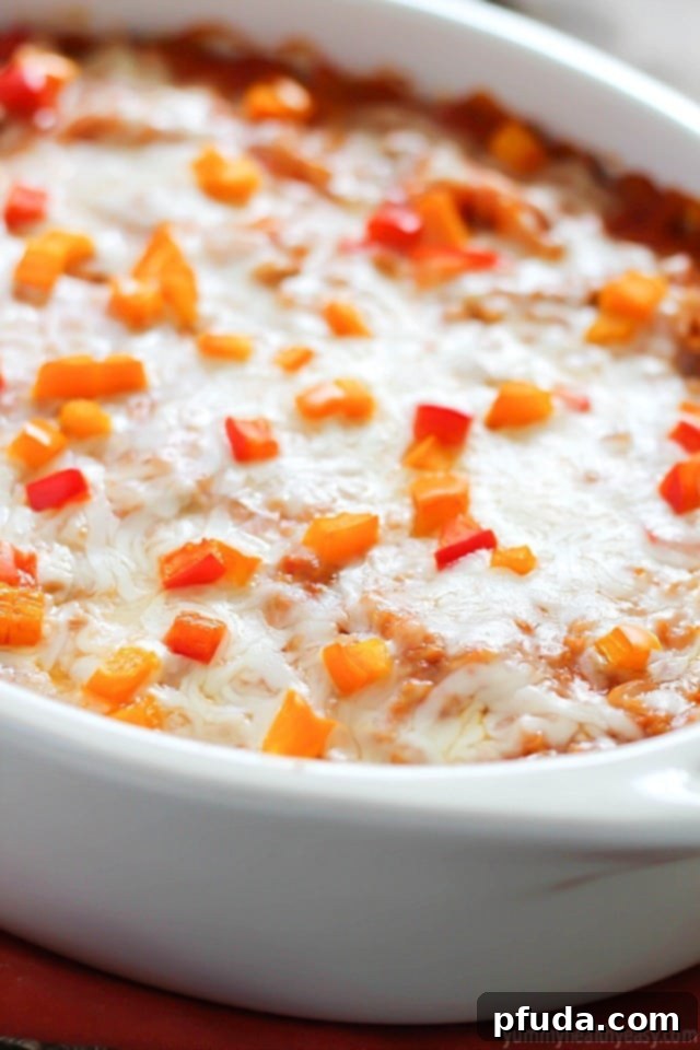 Close-up of a serving of deconstructed stuffed pepper casserole, showing the rich blend of ground turkey, rice, bell peppers, tomato sauce, and melted cheese, ready to be enjoyed.