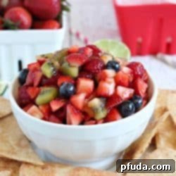 Fresh Fruit Salsa with Crispy Cinnamon Sugar Chips 2 A small bowl of fresh fruit salsa next to a stack of homemade cinnamon chips, presented on a white plate, perfect for a healthy snack.