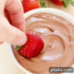 Bright red strawberry is dunked into a creamy Chocolate Yogurt Dip + 43 Healthy Snack Ideas