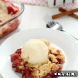 Close-up of a single serving of Strawberry Dump Cake with a golden crust and visible fruit, perfect with ice cream.