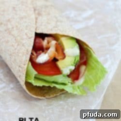 Bacon, Lettuce, Tomato & Avocado wrap on some parchment paper.