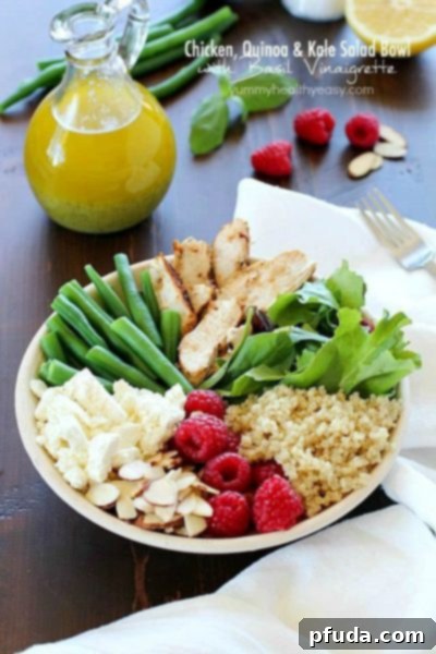 Yummy salad bowl recipe full of grilled chicken, cooked quinoa, kale, raspberries, sliced almonds, feta cheese, green beans and a homemade basil vinaigrette. Super healthy and absolutely delicious!