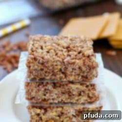 S'mores Rice Krispies Treats 2 Close-up of a single S'mores Rice Krispies Treat square, showing the gooey marshmallow, chocolate cereal, and graham cracker bits.