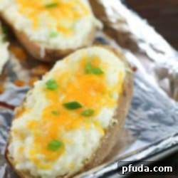 A close-up shot of the perfectly golden-brown and creamy healthy twice baked potatoes, garnished with fresh chives, ready to be enjoyed.