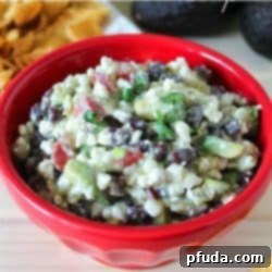 Bright red bowl filled with Cottage Cheese Taco Dip with fresh toppings.