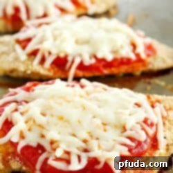 A healthy baked Skinny Chicken Parmesan recipe ready to be served. This lightened-up comfort food dish is easy to make and perfect for a family dinner.